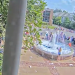 American girl pours washing powder into City Hall fountain into bubble bath